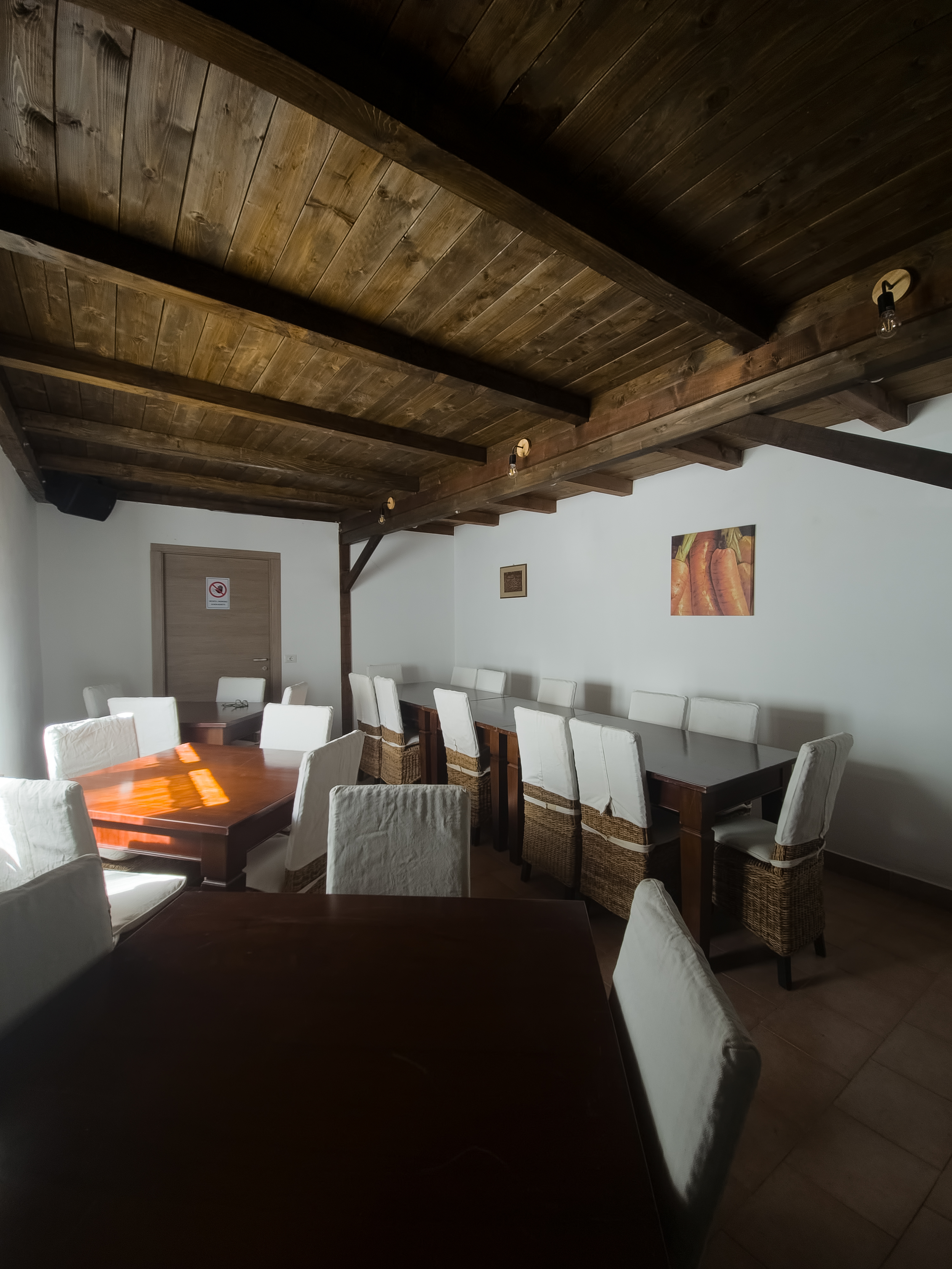 Sala da pranzo con travi in legno e tavoli eleganti